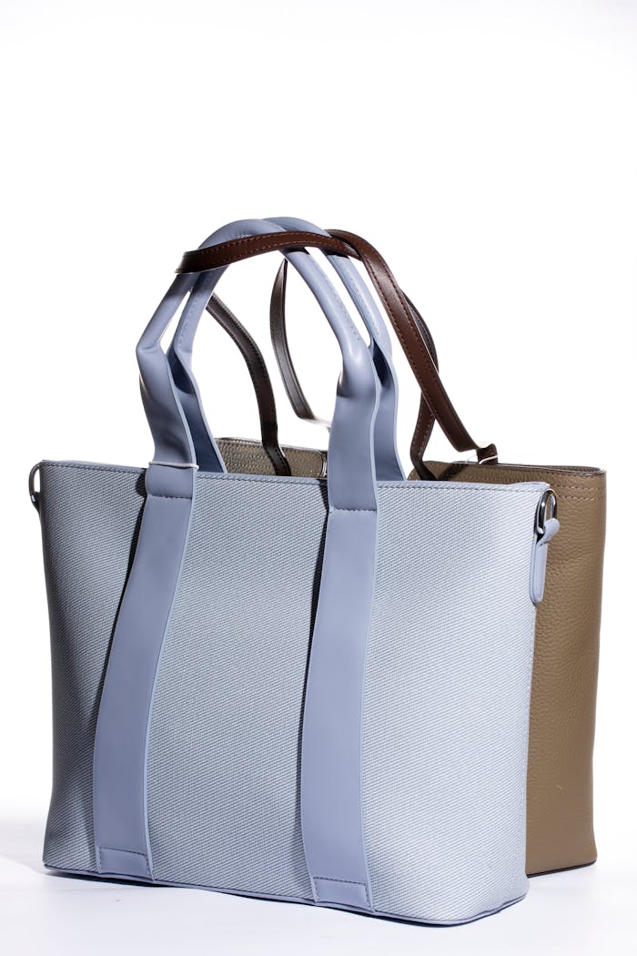 why-choose-us Two elegant tote bags in blue and tan displayed on a white backdrop showcasing modern style.